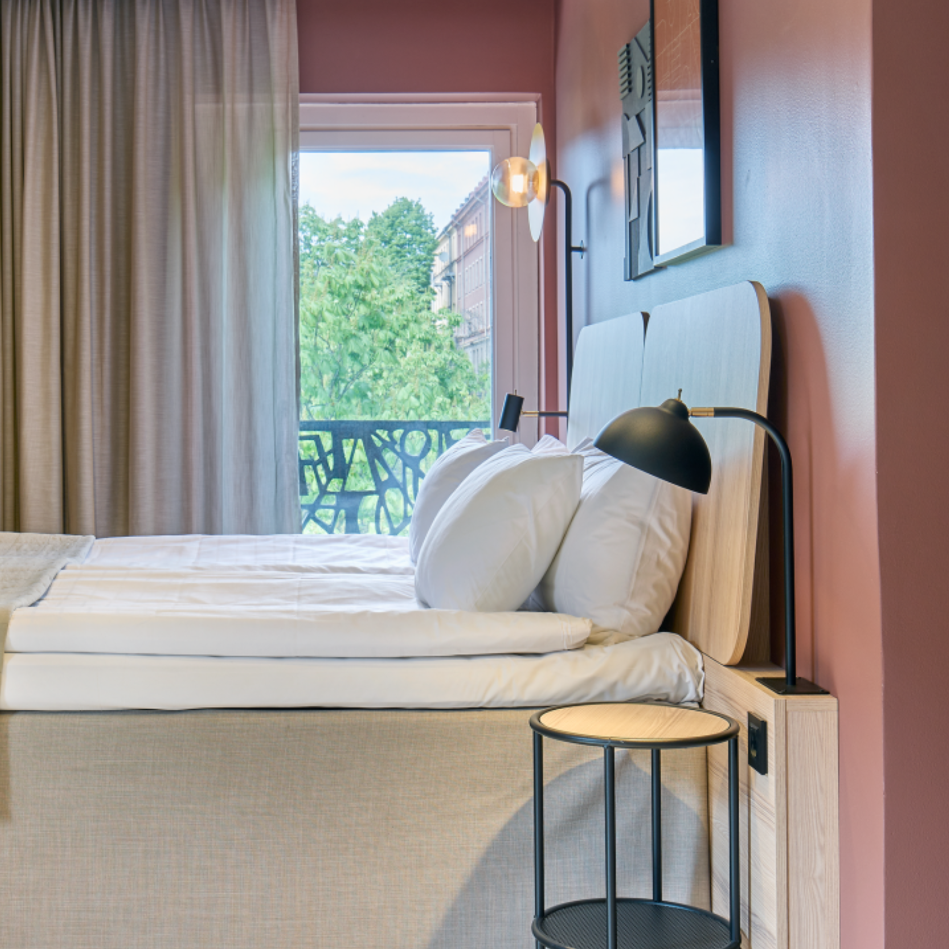 Ett hotellrum med en beige säng och rosa väggar.